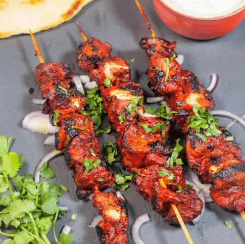 Brochettes de chicken tikka grillées, garnies de coriandre fraîche