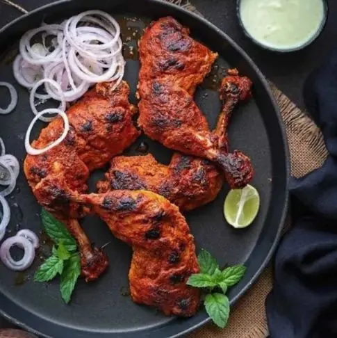Cuisses de poulet tandoori grillées, servies avec oignons et citron